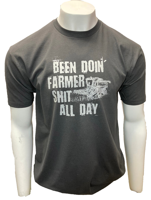 Dark Grey tee shirt. Graphic of tractor harvesting. Shirt reads Been Doin' Farmer Shit All Day.