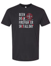 Black short sleeved tee is 100% ringspun cotton. Has white and red graphic BEEN DOIN' FIREFIGHTER SHIT ALL DAY IMPRINTED ON FRONT. Designed by Scratchpad Tees. Sizes Small to 3XL