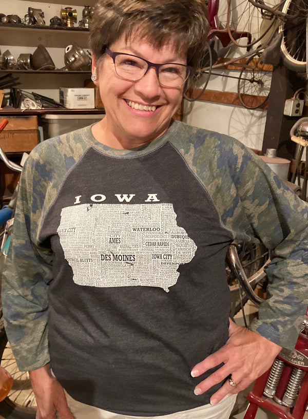 A Dark grey and Camo sleeved adult unisex baseball tee with a graphic of Iowa and the town names in it.