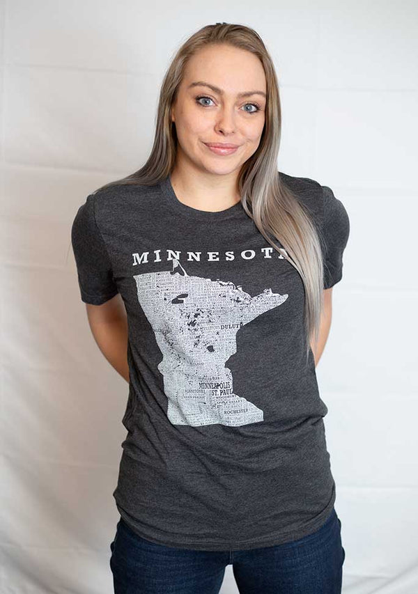 A Dark Grey Heather crew neck, cotton polyester, short sleeve tee. Front white graphic shows Minnesota and its cities. Sizes small to 3X-Lagre. A Scratchpad Tees  original design.