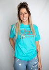 A unisex crew neck short sleeve tee shirt in Tahiti Blue color. A colorful dream catcher is on the shirt front. Front reads Living The Dream North Dakota.