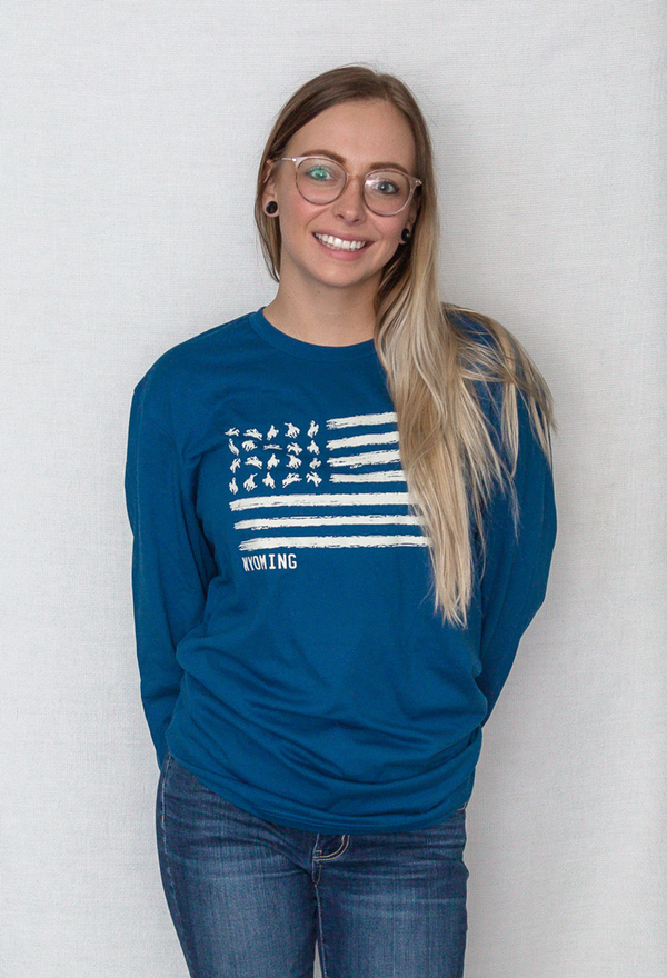A Cool Blue colored crew neck unisex long sleeved tee shirt. The graphic resembles the U.S. flag with images of Bucking Broncos in the stars field. The word WYOMING is placed directly under the graphic