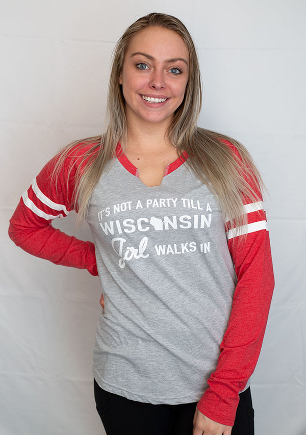 A ladies cut long sleeve notched collar jersey styled tee shirt. Light grey body with red sleeves. Front graphic reads It's Not A Party Till A Wisconsin Girl Walks In.