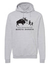 A mock up of a Heather Grey hooded, pouch front sweatshirt. The front graphic includes a charging buffalo launching a tourist family up in the air. The caption reads; Tossin' Tourists since 1889 in North Dakota.