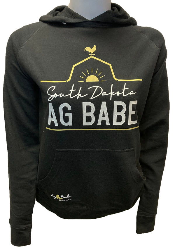  A female mannequin wearing a unisex, black pouch front hooded sweatshirt. A front graphic in gold and white shows a barn roof line, rooster and sun with sun rays. Just under the roof line large lettering reads South Dakota Ag Babe
