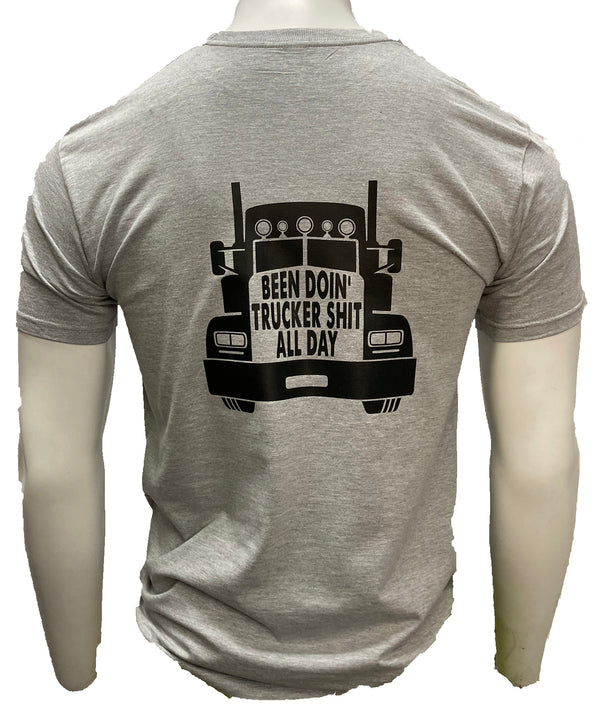 Light grey short sleeve tee with black graphic  of semi truck on the shirt back.Across the truck grill reads Been Doin' Trucker Shit All Day. Sizes Medium to 3X-Large